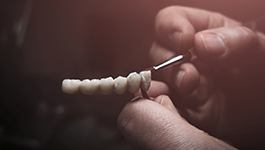Dental technician painting artificial teeth