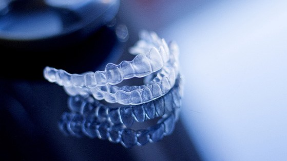 Clear aligners on dark, reflective surface