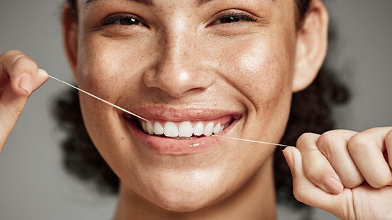 Woman flossing her teeth