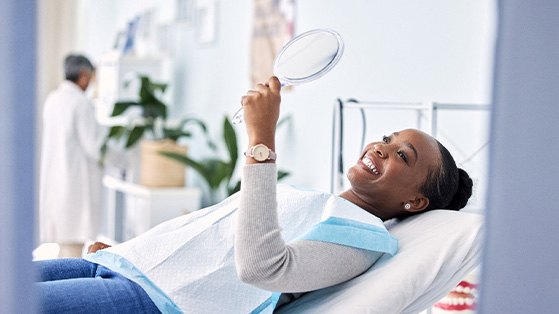 Woman smiling while looking at reflection in mirror