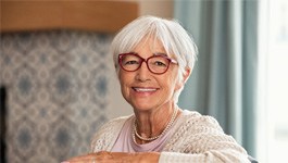 Woman smiling while sitting on couch at home