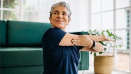 Woman smiling while stretching on floor