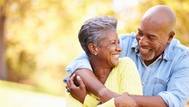 Couple smiling while hugging outside