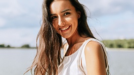 Woman smiling with body of water in background