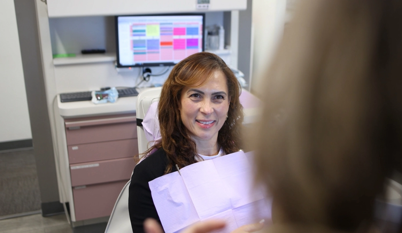 Woman smiling at her cosmetic dentist in Wakefield