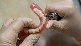 Dental technician polishing a denture