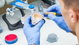 Dental technician carving denture mold