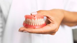 Dentist holding dentures