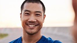 man smiling while standing outside 