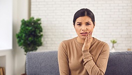 woman holding jaw in pain 