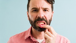 man pointing to inflamed gums 