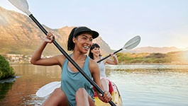 Friends smiling while kayaking on lake