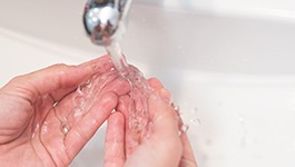 Patient rinsing clear aligners in sink