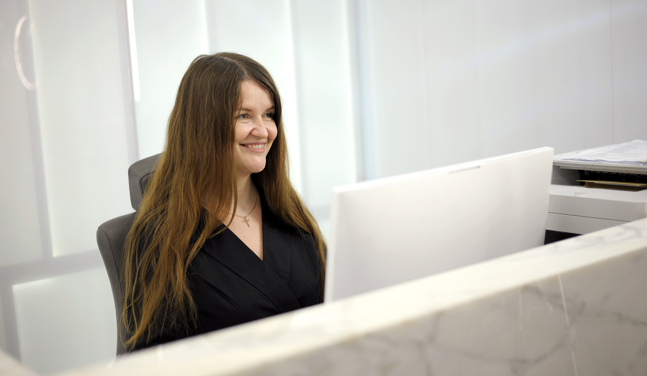 Smiling dental office receptionist at the front desk