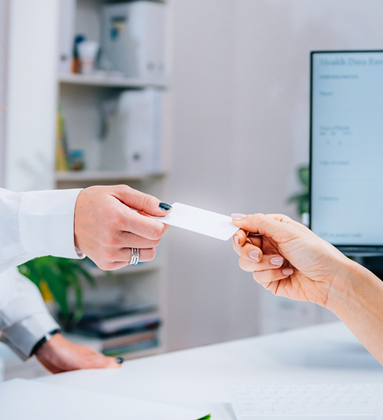 Dental patient handing their payment card to a team member