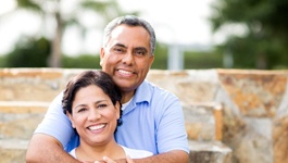 An older couple hugging outside.