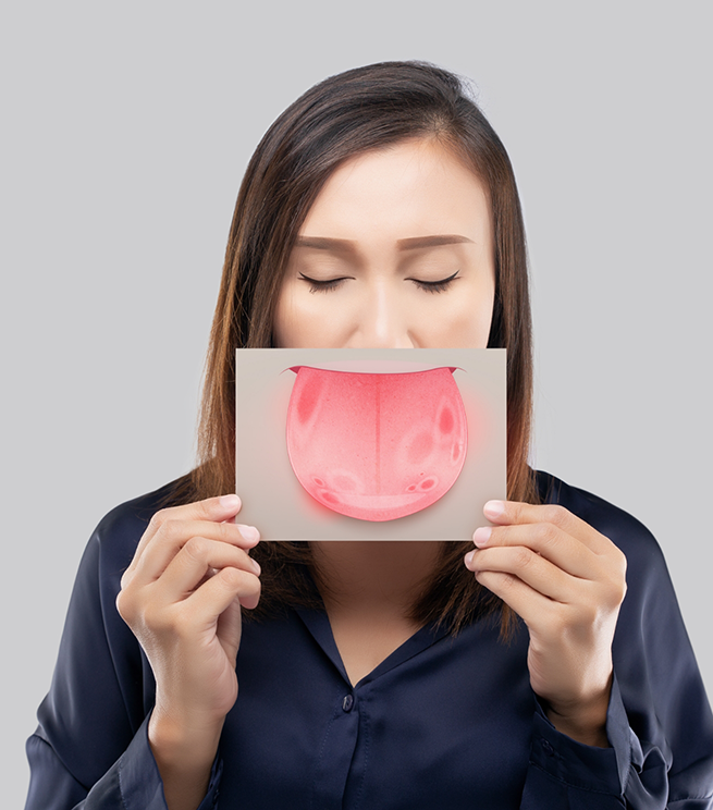 Woman holding a paper in front of her face with a drawing of a tongue on it