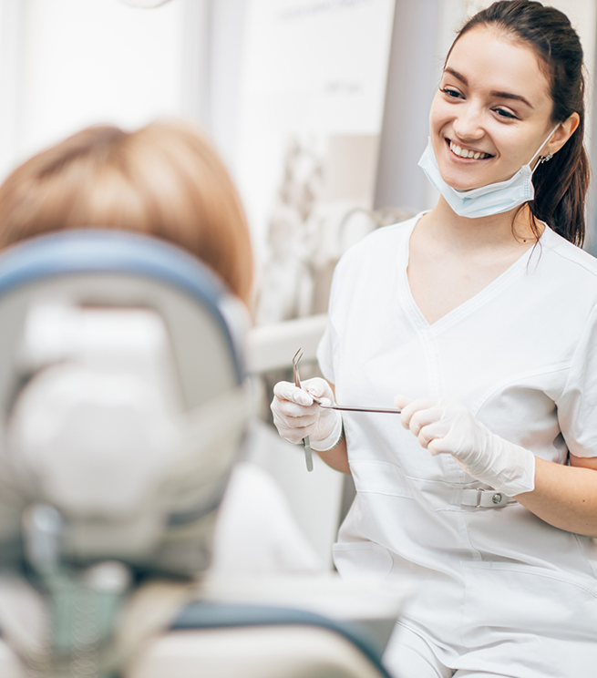 Dentist smiling at a patient in the treatment chair
