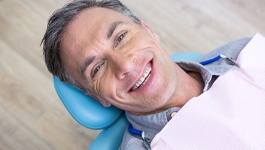 Man smiling in dental chair after periodontal disease treatment Wakefield