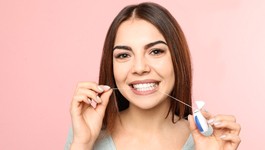 Woman using floss to prevent dental emergencies in Wakefield