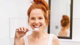 Woman holding a toothbrush and smiling