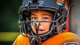 Child wearing a football helmet and mouthguard