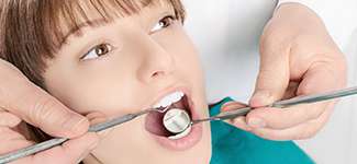 young girl having teeth checked