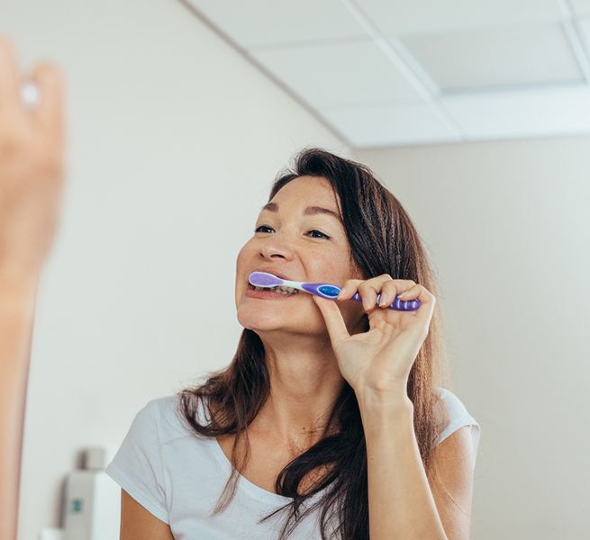 Woman brushing her teeth in bathroom