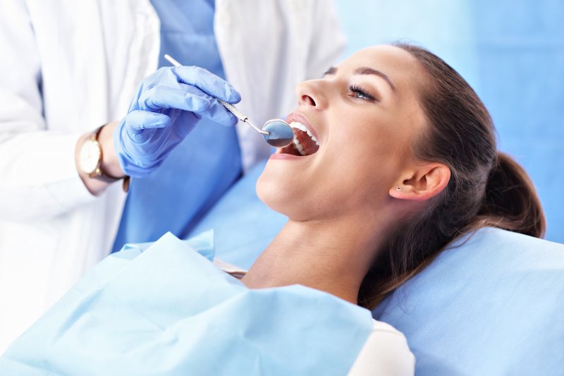 A woman having her teeth checked at the dentist office