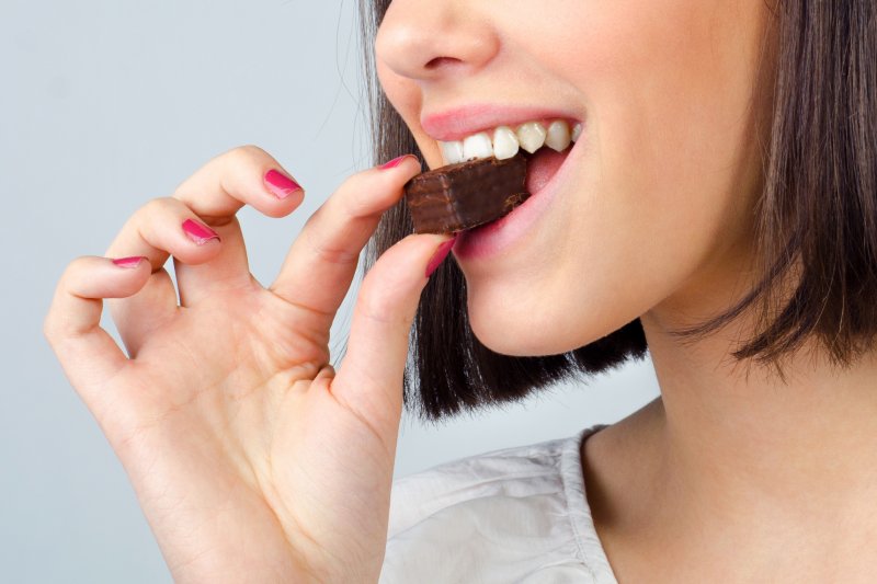 a woman eating a piece of chocolate