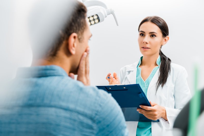 Dentist talking to patient about genetic abnormalities 