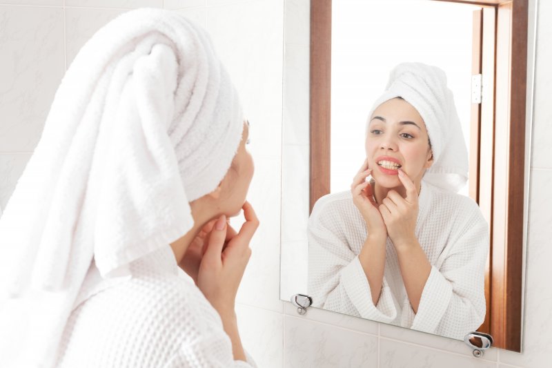 Woman checking her teeth in mirror