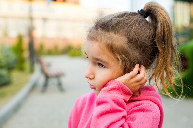 girl holding swollen cheek in Wakefield