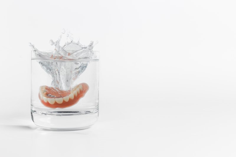Dentures soaking in a glass of water