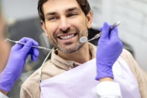 Man smiling after getting cavity between teeth fixed