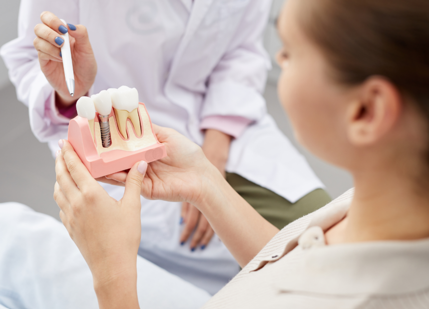 Dentist showing patient model of a dental implant